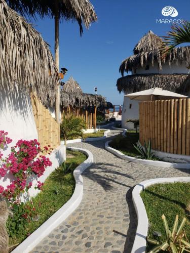 a path to the beach with huts and flowers at Maracol Bungalows Vichayito in Vichayito