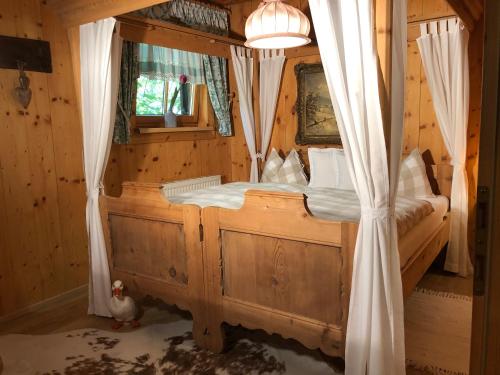 a bedroom with a canopy bed with a window at Alte Mühle Appartements in Seefeld in Tirol