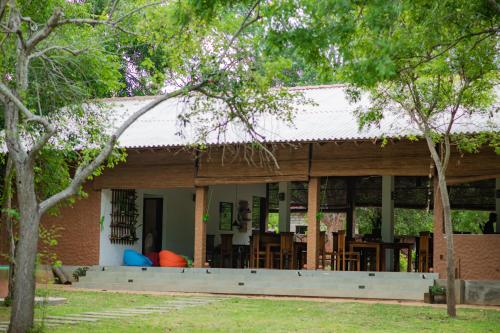 a house with a porch with tables and chairs at Tranquil Wild in Tanamalwila