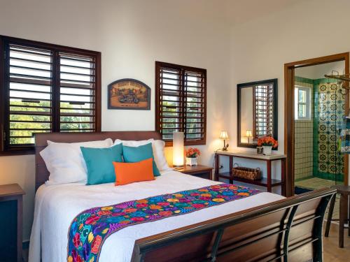 sypialnia z dużym łóżkiem z kolorowymi poduszkami w obiekcie Casa Zarah w mieście Puerto Morelos