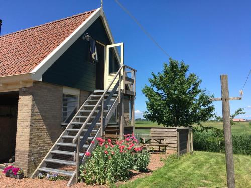 a blue house with a staircase leading up to it at B&B en Vakantiehuisje Ursula in Workum