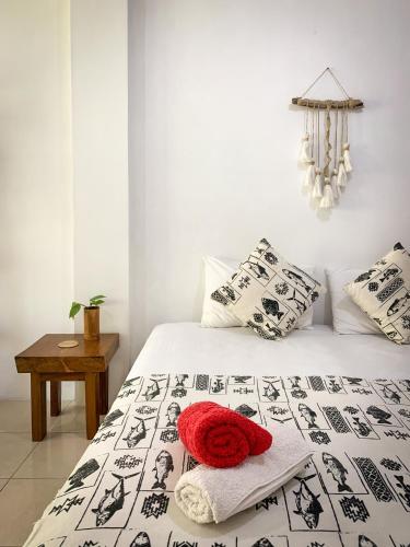 a bedroom with a black and white bed with a red hat on it at 3WILL Bunaken Dive Resort in Bunaken