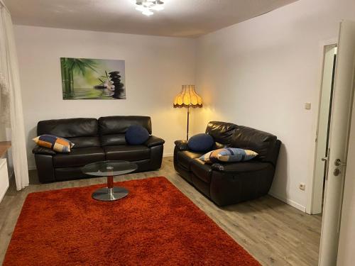 a living room with two leather couches and a table at Ferienwohnung Julia in Vlotho