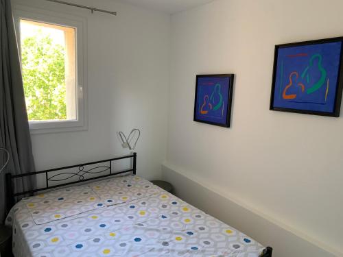 - une chambre avec un lit et deux photos sur le mur dans l'établissement T2 - Quartier mythique du panier, à Marseille