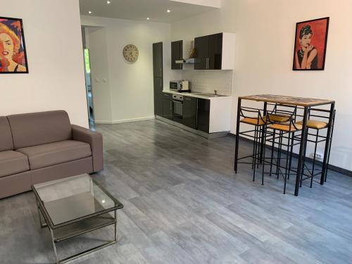 un salon avec un canapé et une table et une cuisine dans l'établissement T2 - Quartier mythique du panier, à Marseille
