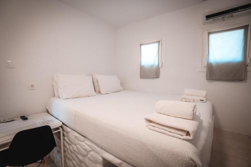 a bedroom with a white bed with towels on it at Esmeralda Apartments in Apollonia