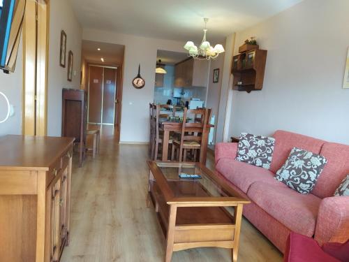 a living room with a red couch and a table at Apartamentos Ball Benas Edificio Prados de Velarta in Cerler