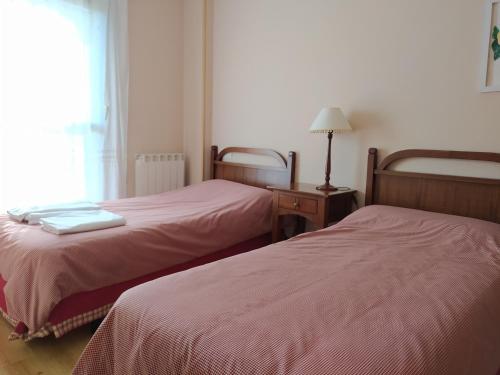 two beds in a small room with a window at Apartamentos Ball Benas Edificio Prados de Velarta in Cerler
