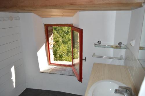 uma casa de banho com uma janela numa pequena casa em La Calade de Craysoules em Bassurels