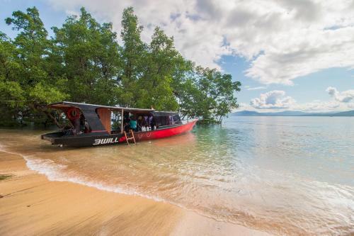 a boat parked on the shore of a beach at 3WILL Bunaken Dive Resort in Bunaken