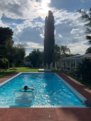 a person sitting in a chair in a swimming pool at Copperbelt Executive Accommodation Ndola, Zambia in Ndola