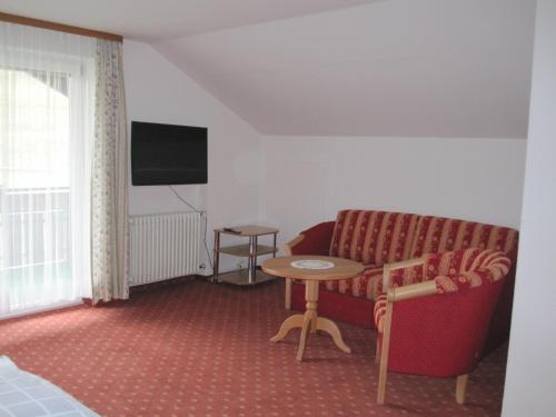 a living room with a couch and a table at Gästehaus Wiesenhof in Fischen