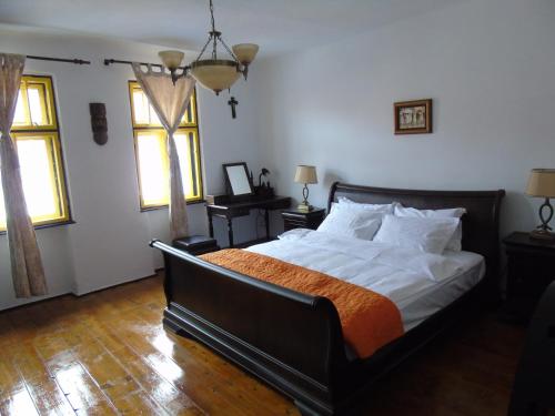 a bedroom with a large bed and two windows at The Dream House of Racos in Racoşu de Jos