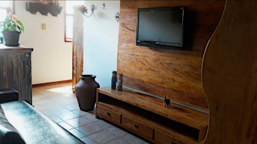 a living room with a television on a wooden wall at Hospedaria e Hostel da Déia in Ouro Preto