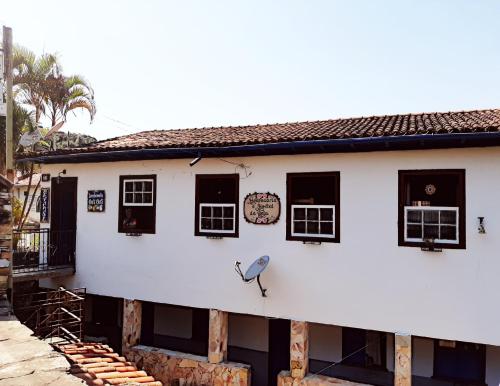 a white building with windows and a clock on it at Hospedaria e Hostel da Déia in Ouro Preto