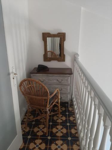 a hallway with a chair and a dresser with a mirror at Domaine du Bois d'Amont in Cabris