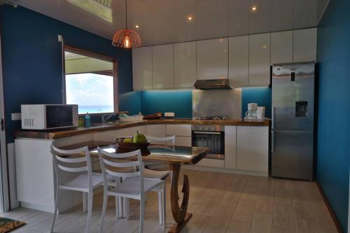 a kitchen with a table and chairs and a refrigerator at Bienvenue au Mati House in Fitii