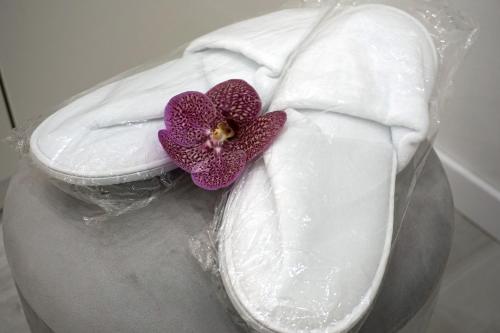 a purple flower sitting on top of a white pillow at Noemiz Exclusive Apartments in Budapest