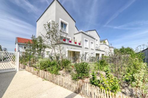 uma casa branca com cerca e plantas em Studio Signature - near Disneyland Paris and shopping center em Montévrain