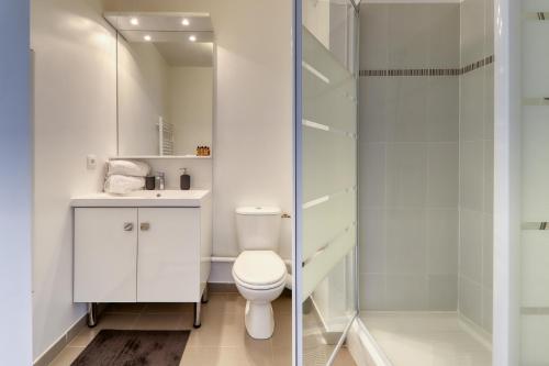 uma casa de banho branca com um WC e um chuveiro em Studio Signature - near Disneyland Paris and shopping center em Montévrain