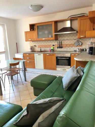 a living room with a green couch in a kitchen at Villa la Libertà! in Koper
