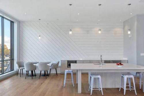 a kitchen with a table and some chairs and a counter at Luxury apartment with gym, steps from commuter rail #4011 in Reading