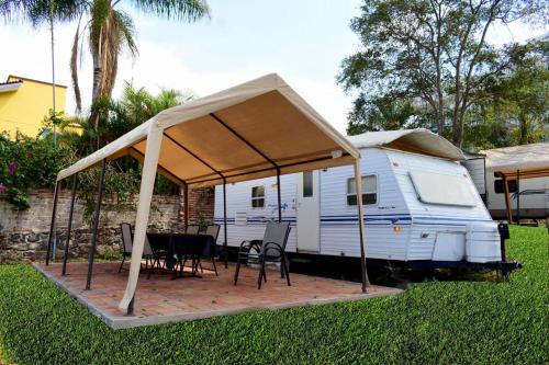 an rv with a tent and a table and chairs at Casa Bravía - Hotel·RV in San Luis Soyatlán