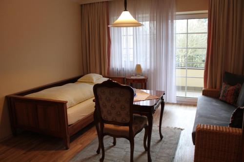 a bedroom with a bed and a table and a couch at Appartementhaus Wimmerhof in Bad Füssing