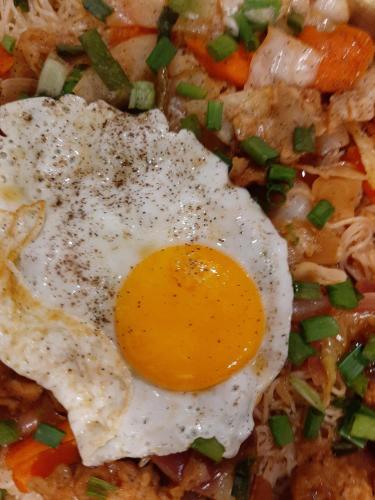 a fried egg on top of a plate of food at Apurba's Pensione in Guwahati