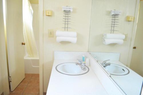 a bathroom with a sink and two towels at Budget Inn Fairmont in Fairmont