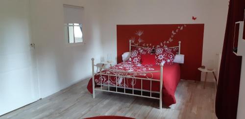 a red bed with a red and white bedspread at La Ferme De Sicard in Terssac