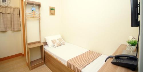 a small room with a bed and a telephone at Anri Pension House in Cebu City