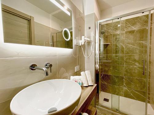 a bathroom with a white sink and a shower at Hotel Victoria in Cuneo