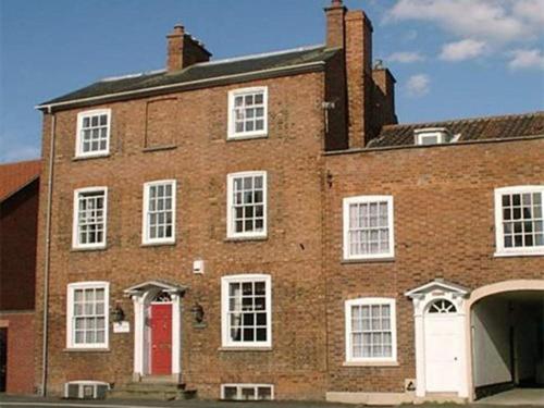 un gran edificio de ladrillo con puerta roja en The Red House en Grantham