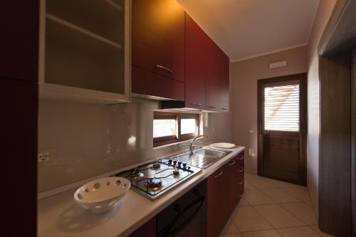 a kitchen with wooden cabinets and a stove top oven at Bono Vacanze Villa San Marco Luxury Holidays Homes in Sciacca