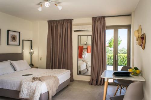 a bedroom with a bed and a desk and a window at Dream Village in Hersonissos