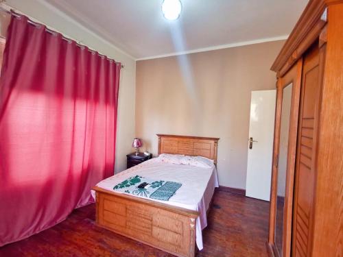 Joya Apartmento في القاهرة: غرفة نوم بسرير وستارة حمراء
