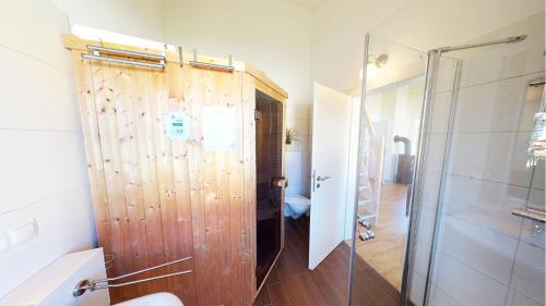 ペルツァーハケンにあるFeriendorf Südstrand Haus 46のバスルーム(シャワー付)、木製のドアが備わります。