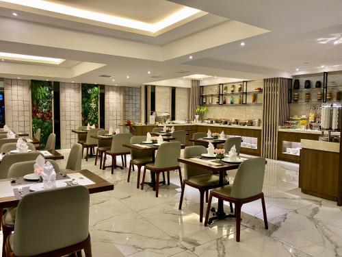 a restaurant with tables and chairs and a bar at UpTown Hotel in Ho Chi Minh City