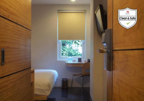 a door to a room with a bed and a window at M Hotel in Jakarta