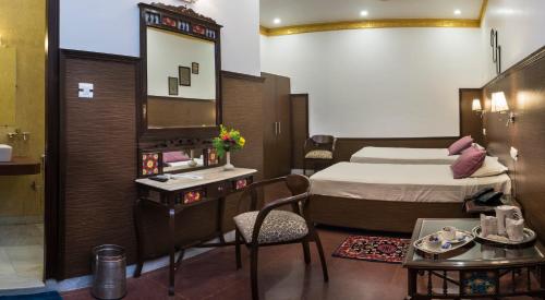 a hotel room with a bed and a mirror at Hotel Harmony in Khajurāho