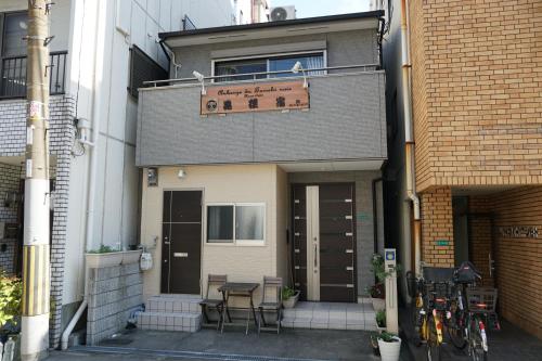 un bâtiment avec un panneau à l'avant dans l'établissement Auberge du Tanuki Noir Maison d'Hôtes, à Osaka
