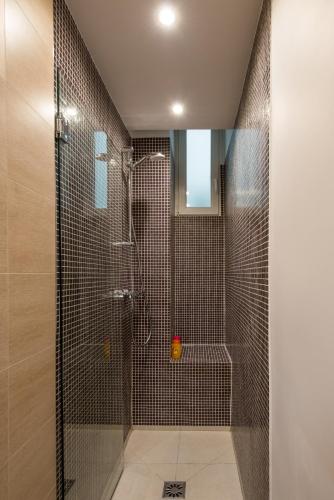 une salle de bain avec une douche avec une porte vitrée dans l'établissement 2 BR Appartement Near Tour Eiffel & Trocadéro, à Paris