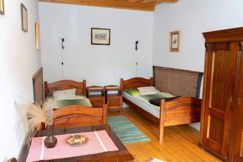 uma sala de estar com duas camas e uma mesa em Koppány Lovasudvar em Bakonykoppány