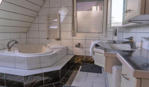 een witte badkamer met 2 wastafels en een bad bij Ferienwohnung in der Mainleite für Vier in Baunach