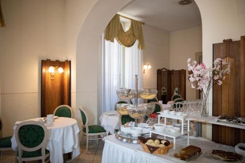 Cette chambre comprend une table avec des assiettes de nourriture. dans l'établissement Hotel Candiani, à Casale Monferrato