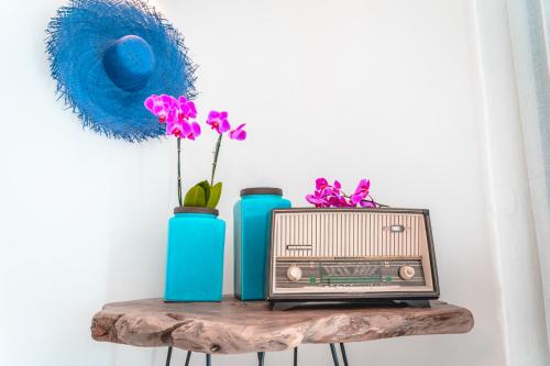 een tafel met een oude radio en twee blauwe vazen bij Sifanto Mare Apartments in Faros