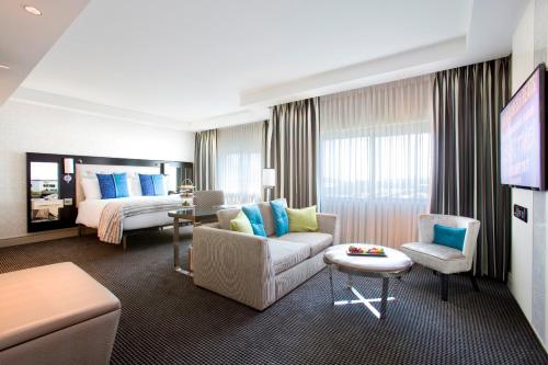 a hotel room with a bed and a living room at Southern Sun Waterfront Cape Town in Cape Town