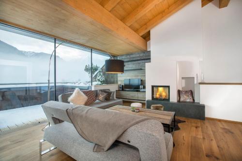 a living room with a couch and a fireplace at Penthaus Kitzebüheler Alpen in Neukirchen am Großvenediger