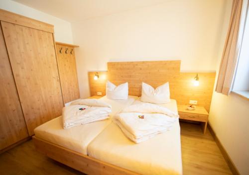 a bedroom with a bed with two pillows on it at Alpchalet Tirol in Berwang